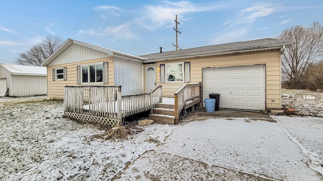 single story home with a wooden deck and a garage