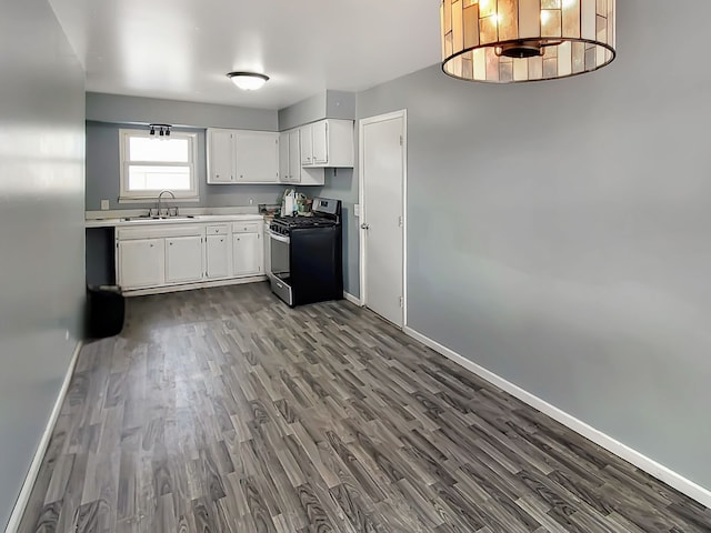 kitchen with white cabinets, dark hardwood / wood-style flooring, stainless steel range with gas cooktop, and sink