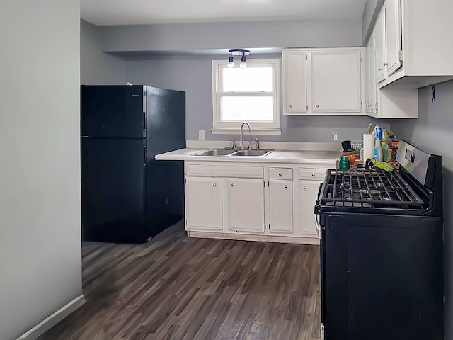 kitchen featuring sink, stainless steel gas range oven, dark hardwood / wood-style floors, black refrigerator, and white cabinets