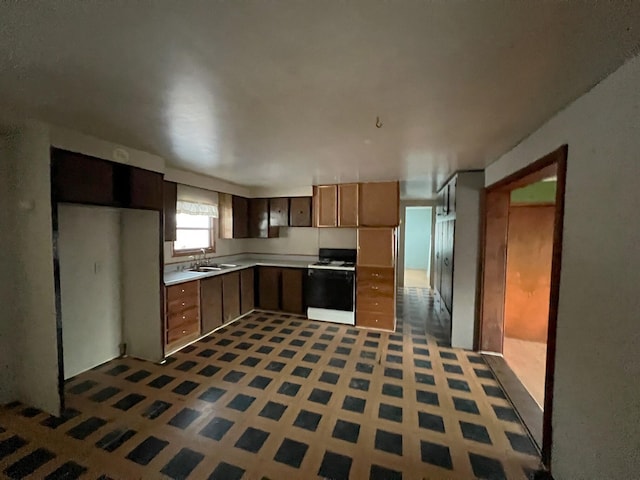 kitchen featuring tile patterned floors, white gas range, and sink