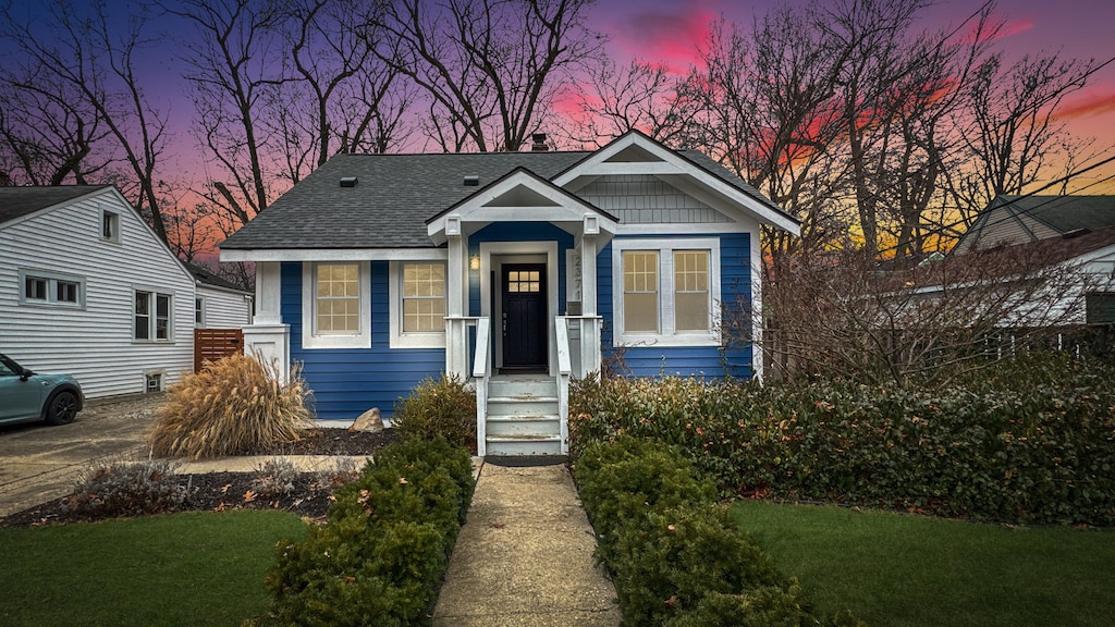 bungalow-style home with a yard