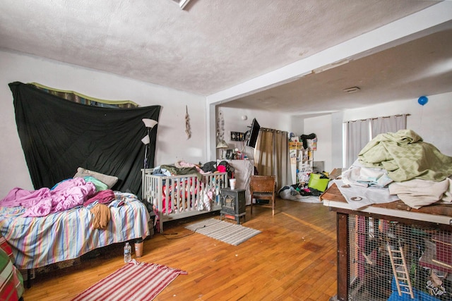 bedroom featuring hardwood / wood-style flooring and a textured ceiling