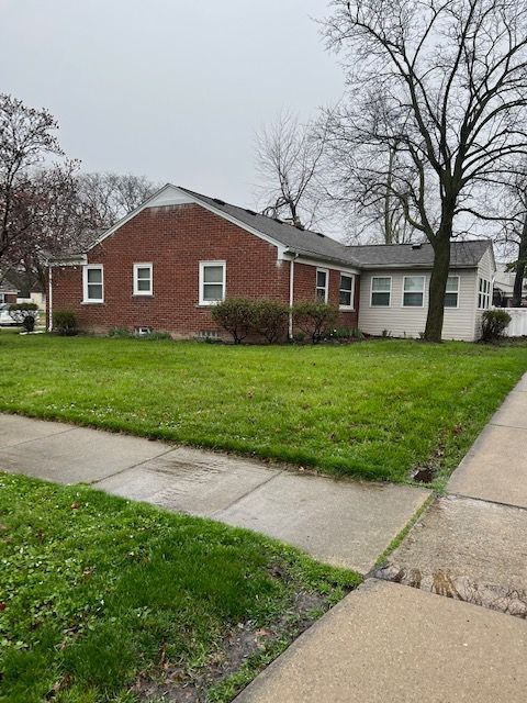 1220 Elford Ct, Grosse Pointe Woods, MI 48236 - view of home's exterior with brick siding and a yard