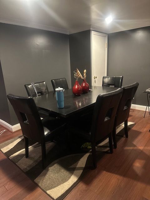 dining space featuring wood-type flooring and ornamental molding