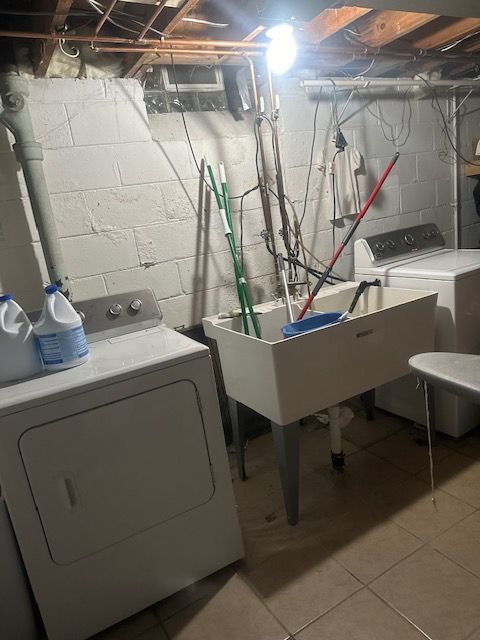 laundry room with tile patterned flooring and washing machine and dryer