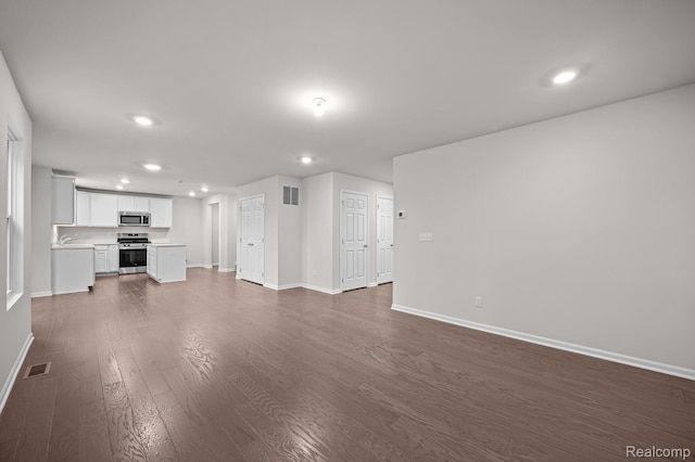14213 Old Oak Trl, Van Buren, MI 48111 - unfurnished living room with recessed lighting, baseboards, and dark wood-type flooring