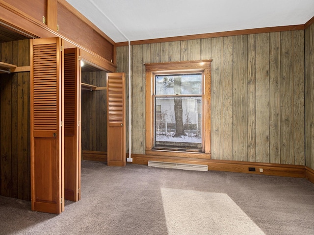 unfurnished bedroom featuring carpet floors, a closet, and wood walls