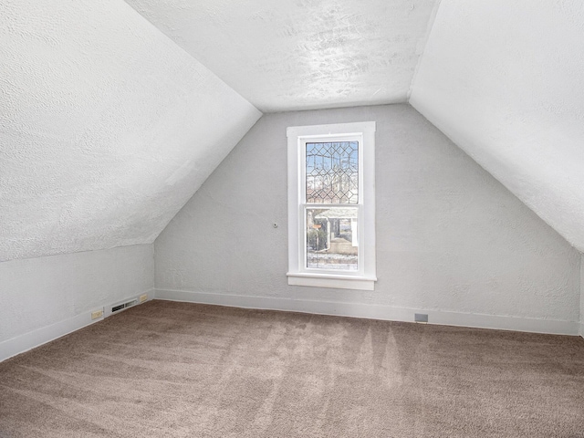 bonus room featuring carpet floors, a textured ceiling, and vaulted ceiling