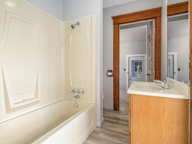 bathroom with bathing tub / shower combination, hardwood / wood-style floors, and vanity