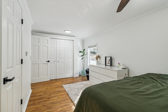 bedroom featuring a closet, ceiling fan, hardwood / wood-style floors, and ornamental molding