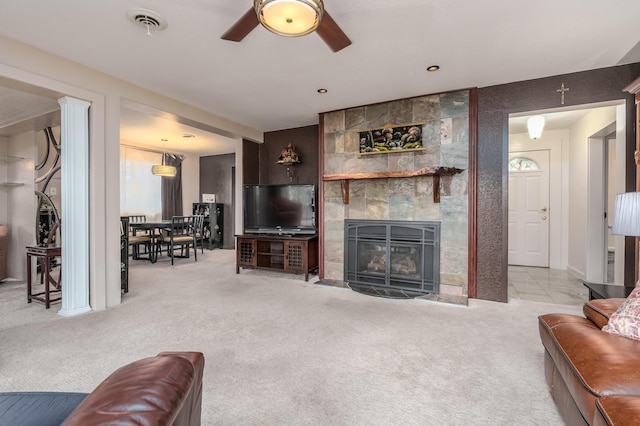 carpeted living room featuring ceiling fan and a tiled fireplace