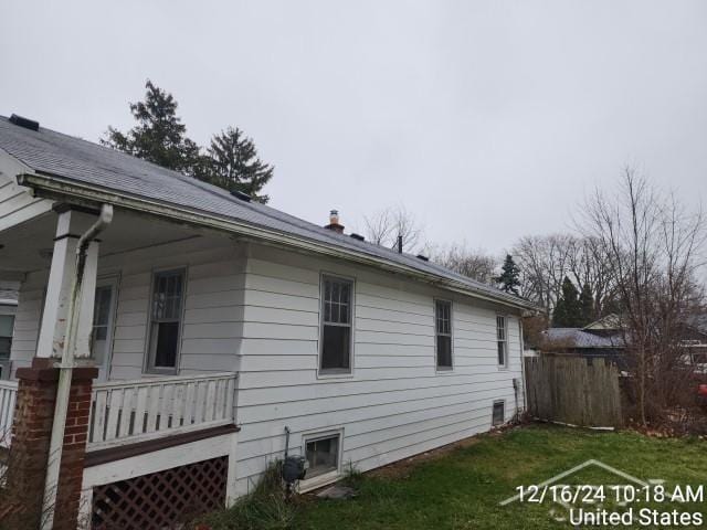 view of side of home featuring a yard and a porch