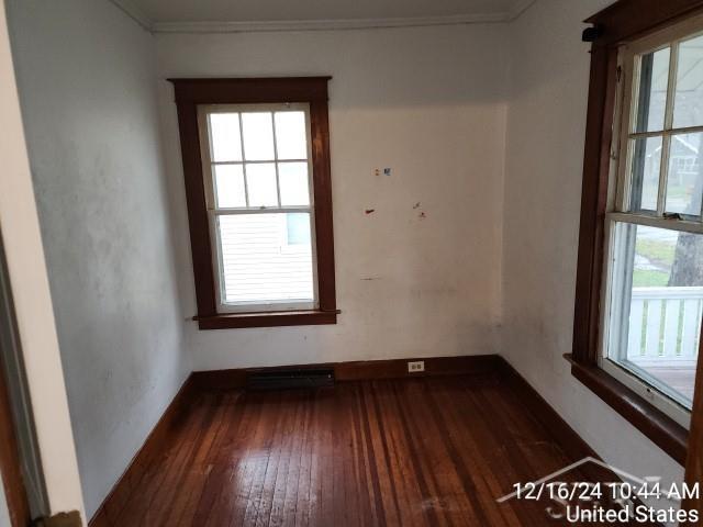 spare room with dark hardwood / wood-style floors and ornamental molding