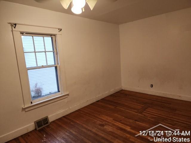 empty room with ceiling fan and dark wood-type flooring