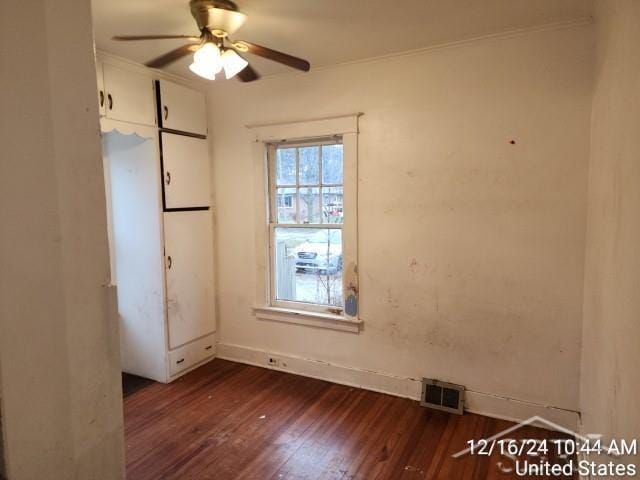 unfurnished room featuring dark hardwood / wood-style floors, ceiling fan, and crown molding