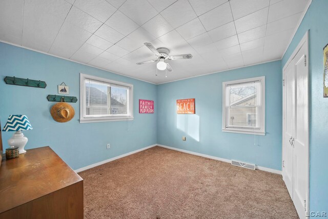 carpeted spare room with ceiling fan and a healthy amount of sunlight