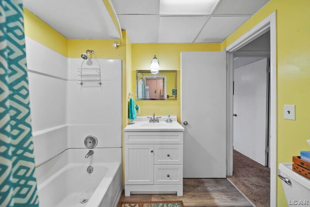 full bathroom featuring toilet, a paneled ceiling, shower / washtub combination, vanity, and hardwood / wood-style flooring