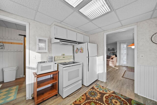 kitchen featuring a paneled ceiling, light hardwood / wood-style flooring, white cabinets, and white appliances