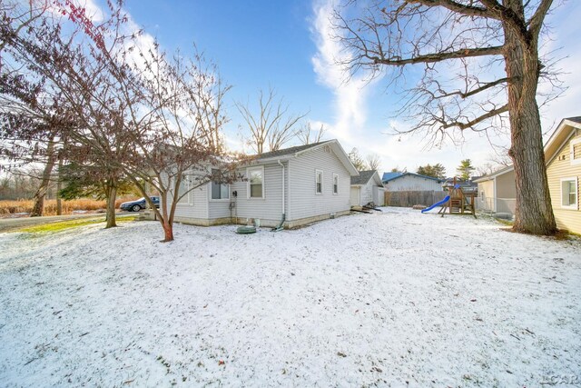 snow covered property with a playground