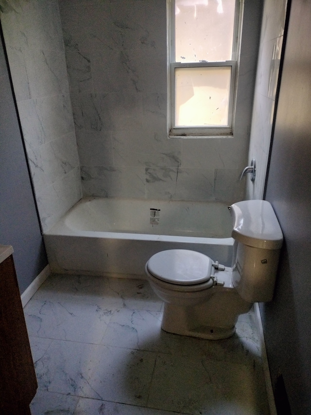 bathroom featuring a tub to relax in and toilet