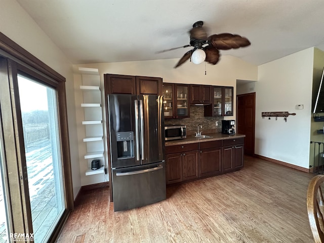 kitchen with vaulted ceiling, sink, decorative backsplash, dark brown cabinetry, and stainless steel appliances