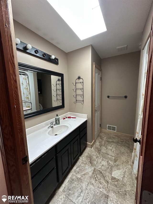 bathroom featuring vanity and a skylight