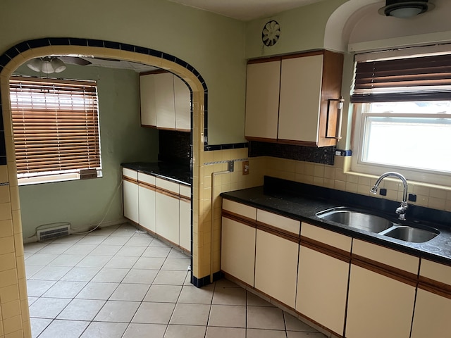 kitchen with backsplash, sink, and light tile patterned floors