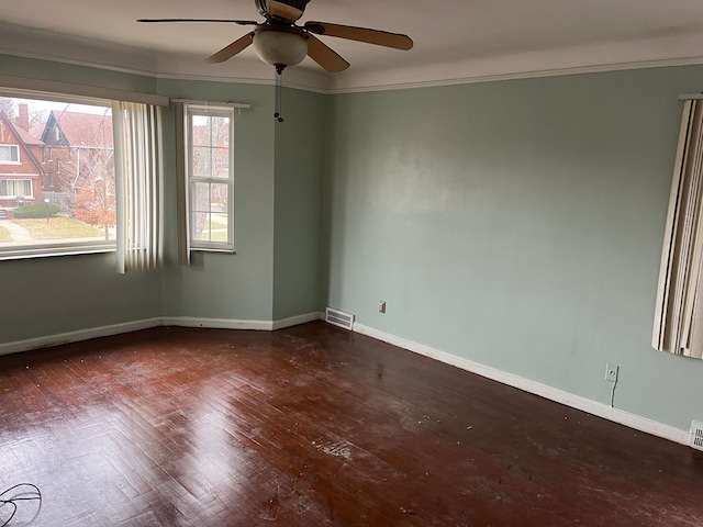 empty room with dark hardwood / wood-style floors, ceiling fan, and ornamental molding