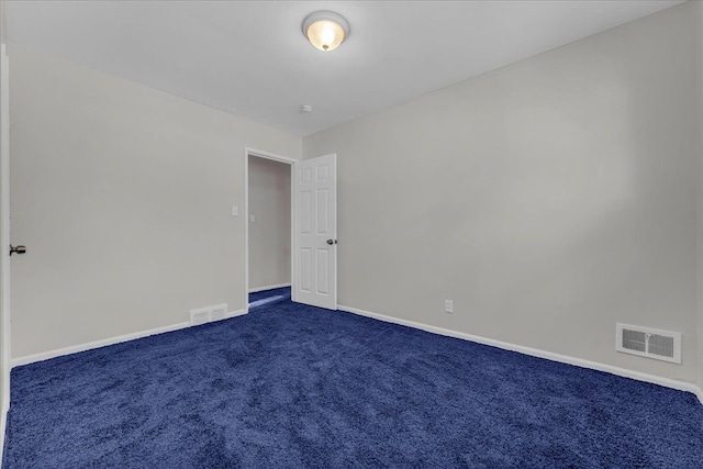 spare room featuring dark carpet