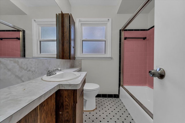 full bathroom featuring toilet, vanity, tile patterned floors, and a wealth of natural light