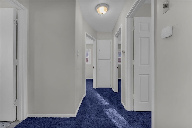 hall featuring dark carpet