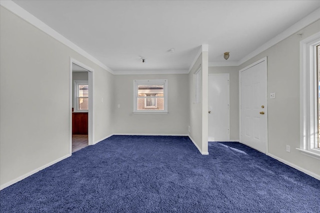 spare room featuring crown molding and dark colored carpet