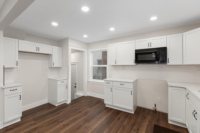 kitchen featuring white cabinets, dark hardwood / wood-style flooring, and backsplash