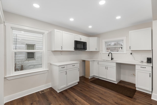 kitchen featuring white cabinetry, dark wood-type flooring, and sink