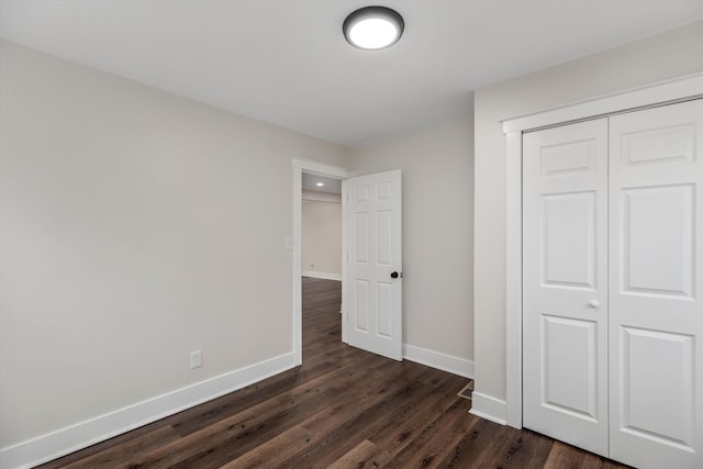 unfurnished bedroom featuring a closet and dark hardwood / wood-style floors