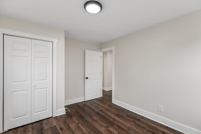 unfurnished bedroom featuring dark hardwood / wood-style floors and a closet