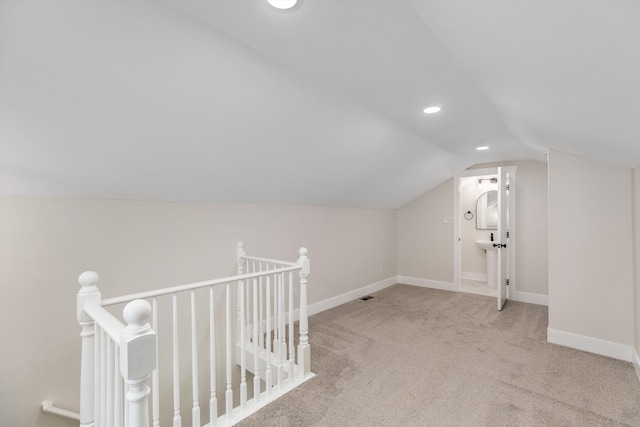 additional living space featuring light colored carpet and vaulted ceiling