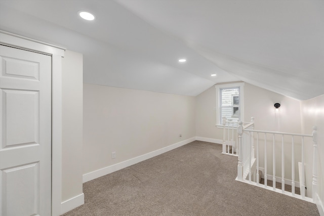 additional living space with carpet flooring and lofted ceiling