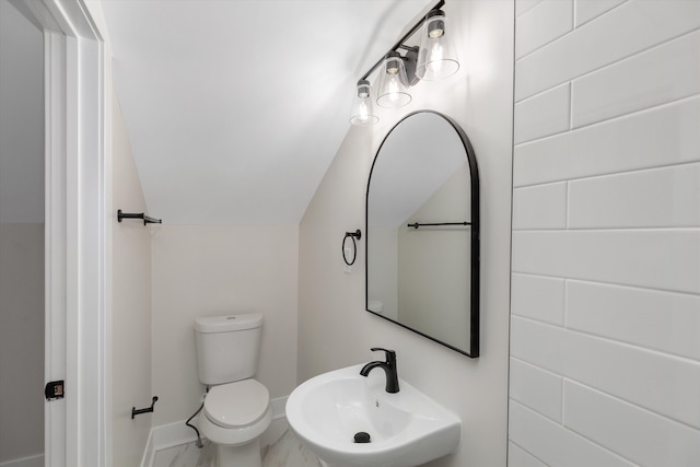 bathroom with sink, vaulted ceiling, and toilet