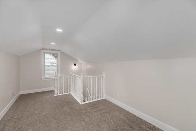 additional living space featuring carpet floors and vaulted ceiling