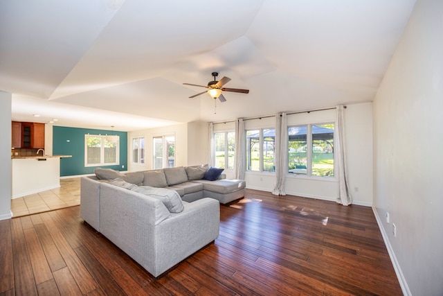 living room featuring dark hardwood / wood-style flooring, ceiling fan, and sink