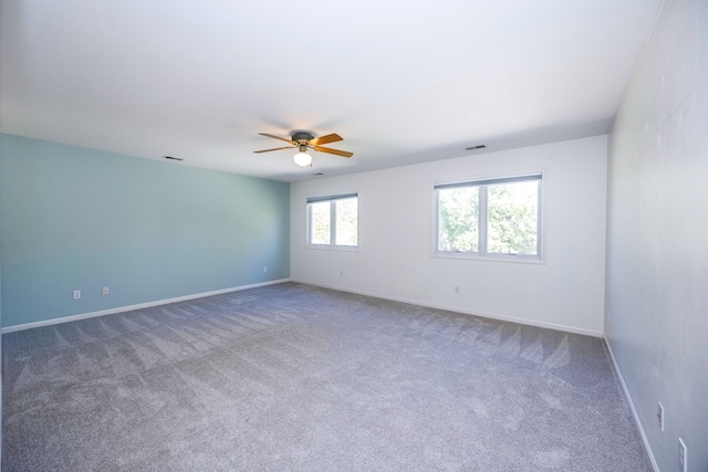 carpeted spare room with ceiling fan