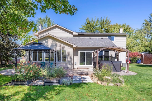 back of house featuring a patio area, a pergola, a yard, and a hot tub