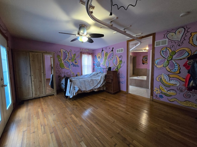 bedroom featuring hardwood / wood-style flooring, ceiling fan, connected bathroom, and track lighting