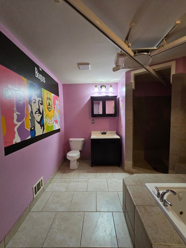 bathroom with a washtub, vanity, and toilet