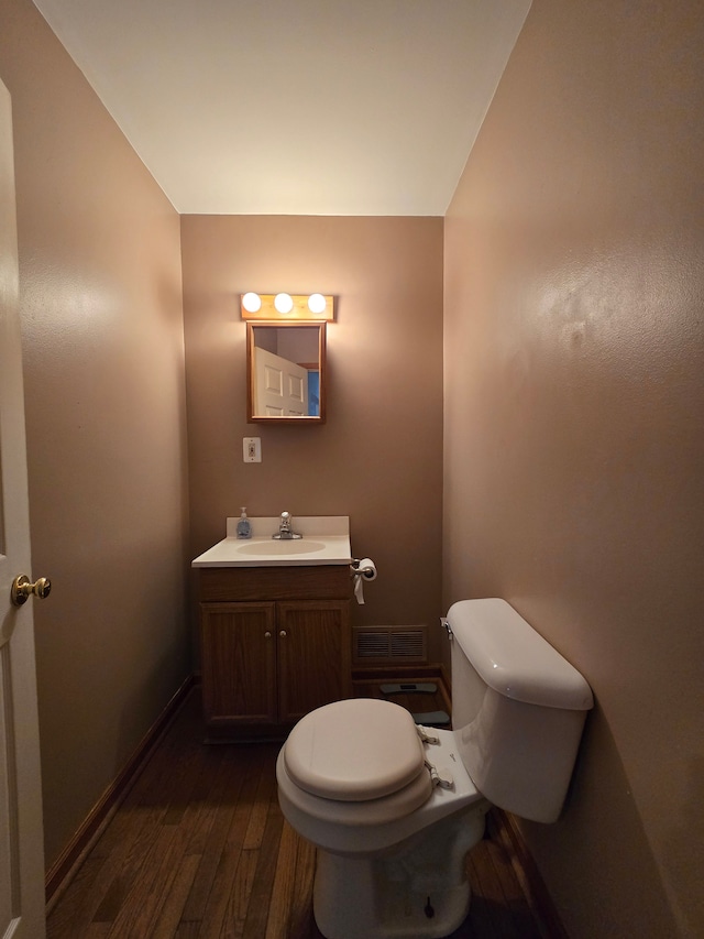 bathroom with vanity, hardwood / wood-style flooring, and toilet