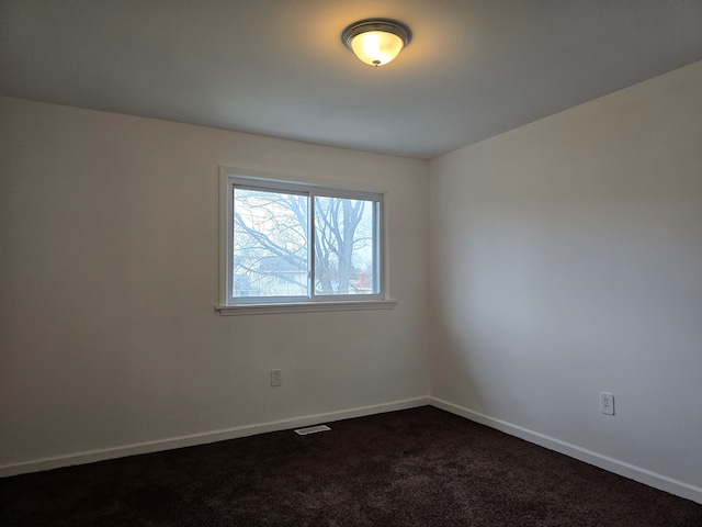 empty room with dark colored carpet