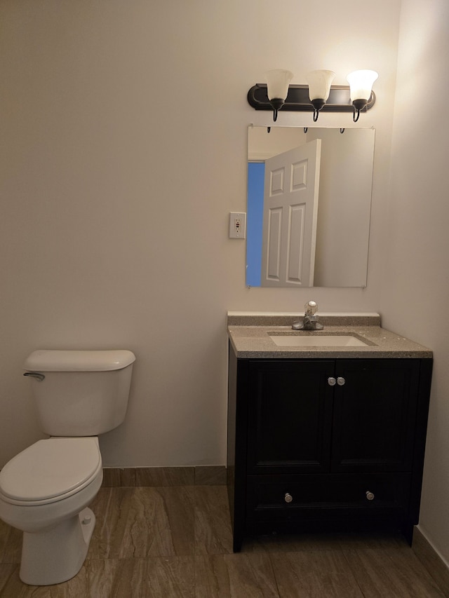 bathroom with hardwood / wood-style floors, vanity, and toilet