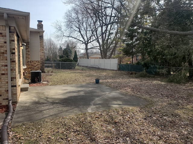 view of yard with cooling unit and a patio