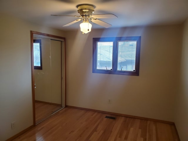 unfurnished bedroom with ceiling fan, light hardwood / wood-style flooring, and a closet